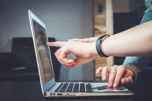 Συνεργασία ομάδας σε laptop για υποστήριξη και κατασκευή ιστοσελίδων